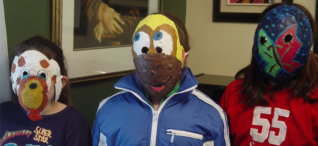 Three of Ginok's students wearing masks they made in Ginok's art classes.